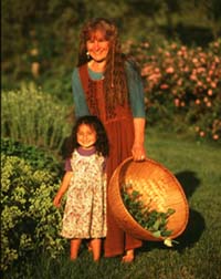 Nancy and Grace Phillips on the path with a basket full of organic healing herbs grown on Heartsong Farm. -- photo: Frank Siteman